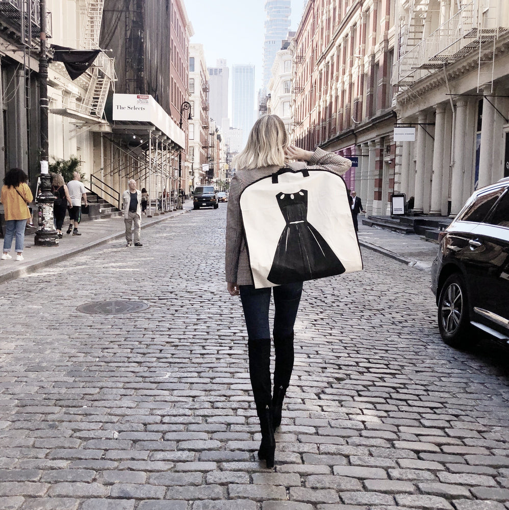 
                                      
                                        LBD garment bag being held by a woman as she walks down the street in NYC. 
                                      
                                    