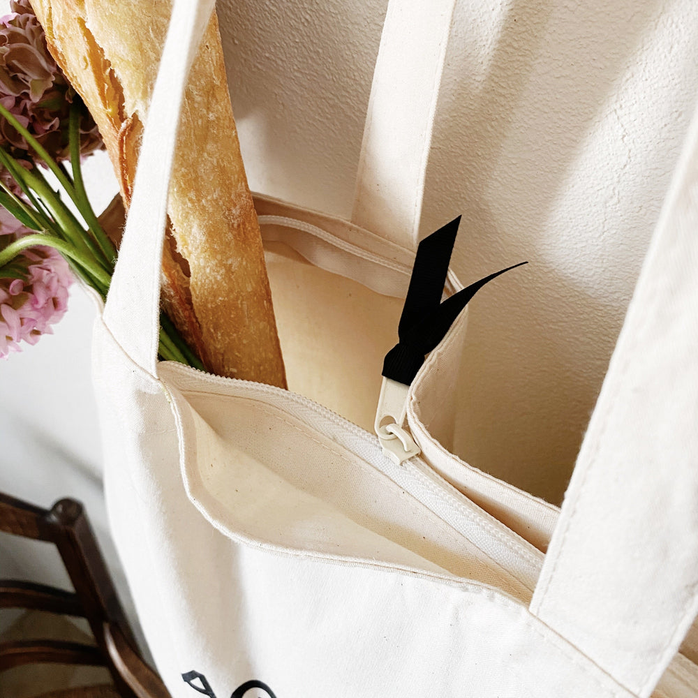 
                                      
                                        Paris zippered tote in white. 
                                      
                                    