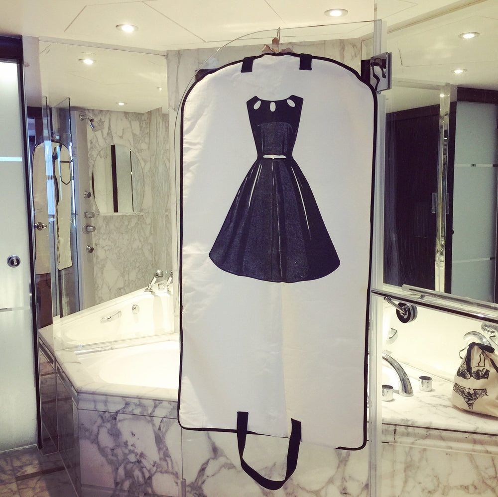 
                                      
                                        A marble bathroom with a LBD garment bag dress hanging off the shower. 
                                      
                                    