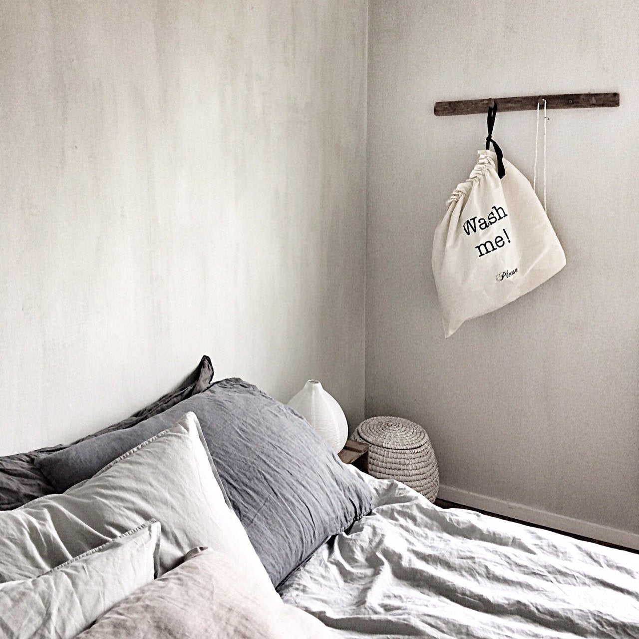
                                      
                                        A bedroom with a large laundry bag hanging from a hook on the wall. 
                                      
                                    